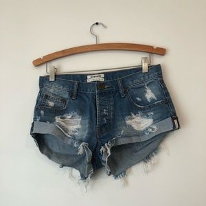 One Teaspoon short jean shorts with distressed ends and button front closure.